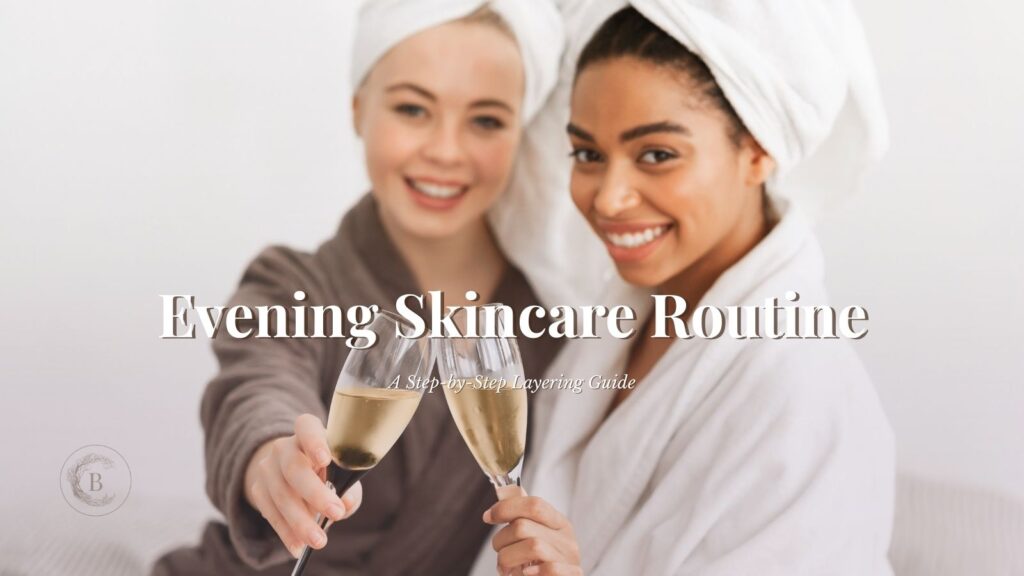 Two women in robes toasting champagne during an evening skincare routine, illustrating the correct night skincare routine order.