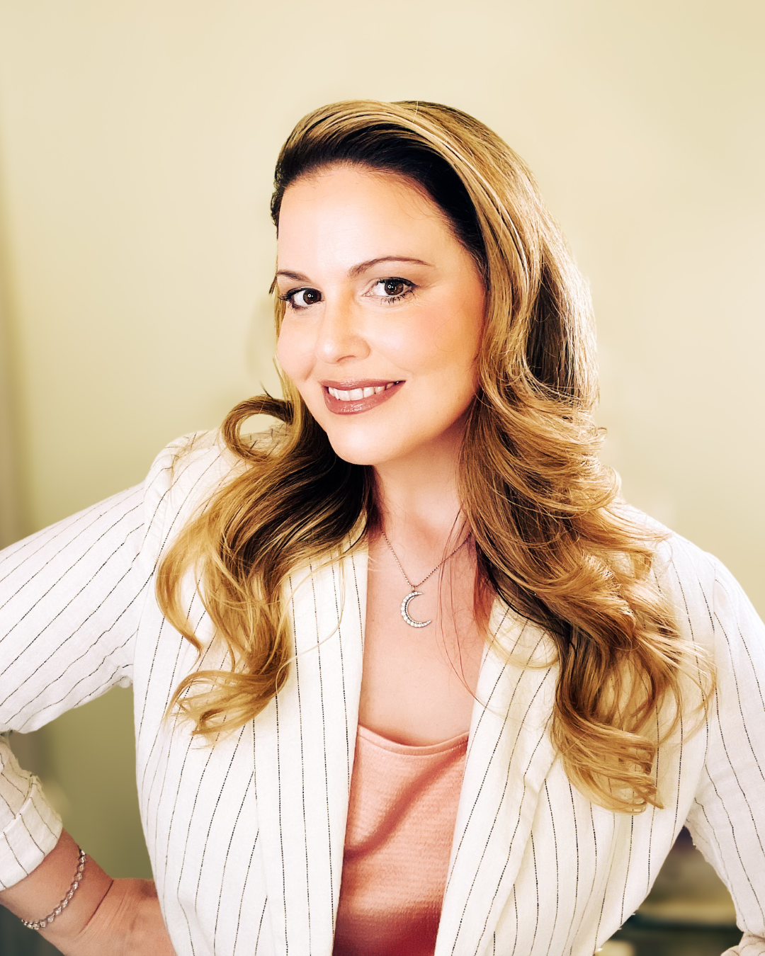 Maria Bella, founder of Bloom by Maria Bella, wearing a white pinstripe blazer